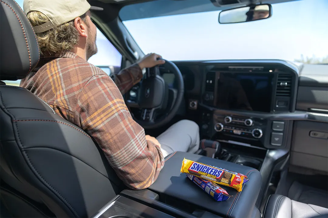 Man driving Raptor Rampage prize vehicle with SNICKERS® candy bars on center console